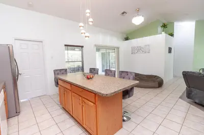 a kitchen with a island in the middle of a room at Gorgeous Fully Furnished 2-Bedroom Luxury Villa in Kissimmee