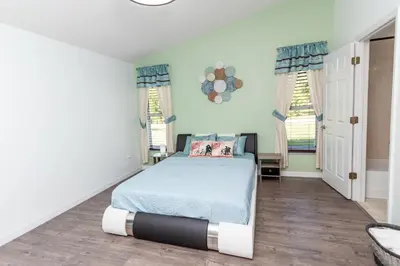 a bedroom with a bed and two windows at Gorgeous Fully Furnished 2-Bedroom Luxury Villa in Kissimmee