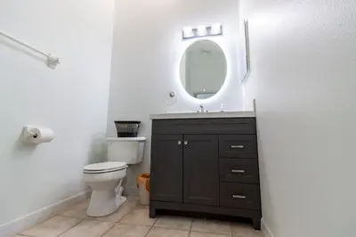 a bathroom with a sink and a toilet and a mirror at Gorgeous Fully Furnished 2-Bedroom Luxury Villa in Kissimmee