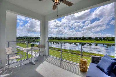a room with a balcony with a view of the water at Serenity Haven, Bliss, Storey Lake By Shine Villas #701 in Kissimmee