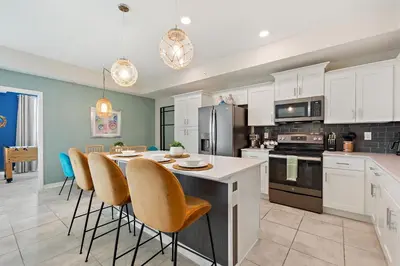 a kitchen with white cabinets and a table with chairs at Serenity Haven, Bliss, Storey Lake By Shine Villas #701 in Kissimmee