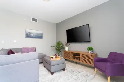 a living room with a couch and a tv at Sweet Suite Sleeps 6 Storey Lake By Shine Villas #903 in Kissimmee