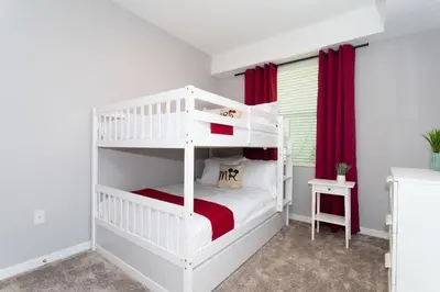 a bedroom with two bunk beds with red curtains at Sweet Suite Sleeps 6 Storey Lake By Shine Villas #903 in Kissimmee