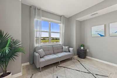 a living room with a couch and a window at Sweet Suite Sleeps 6 Storey Lake By Shine Villas #903 in Kissimmee