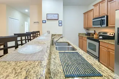 a kitchen with a sink and a counter top at Mickeys Paradise - a fabulous 4 bed Paradise Palms Resort pool home that's close to Disney in Kissimmee