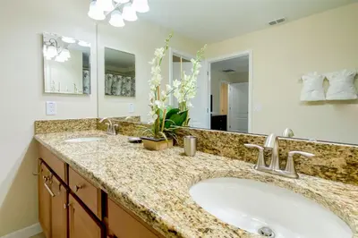 a bathroom with two sinks and a large mirror at Mickeys Paradise - a fabulous 4 bed Paradise Palms Resort pool home that's close to Disney in Kissimmee