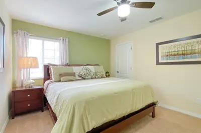 a bedroom with a bed and a ceiling fan at Mickeys Paradise - a fabulous 4 bed Paradise Palms Resort pool home that's close to Disney in Kissimmee