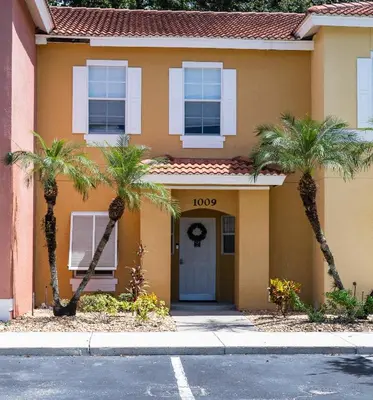a building with palm trees in front of it at Enchanting Escape 3 Bedroom Minutes from Disney! in Kissimmee