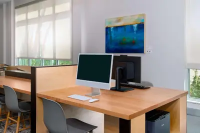 an office with a desk with a computer on it at Hyatt House Orlando Airport in Orlando