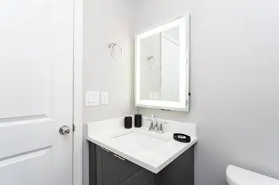 a white bathroom with a sink and a mirror at Amazing Cozy Private Pool - 4404 in Kissimmee