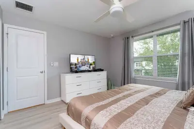 a bedroom with a bed and a tv on a dresser at Amazing Cozy Private Pool - 4404 in Kissimmee