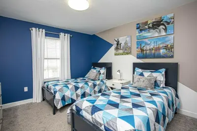 two beds in a bedroom with blue walls at Amazing Lovely Private Pool 4844 in Kissimmee