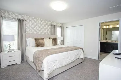 a white bedroom with a bed and a mirror at Amazing Lovely Private Pool 4844 in Kissimmee