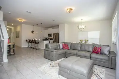 a living room with a couch and a kitchen at Astonishing Home Private Pool 4830 in Kissimmee