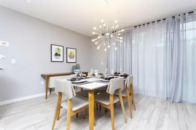 a dining room with a table and chairs and a chandelier at Modern 4 bedroom Home Private Pool 4451 in Kissimmee