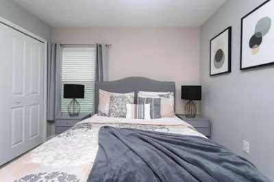 a bedroom with a large bed and two lamps at Modern 4 bedroom Home Private Pool 4451 in Kissimmee