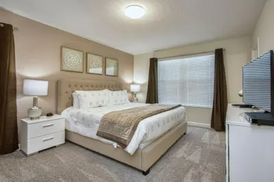 a bedroom with a large bed and a television at 4712 Fabulous Brand-New Private Pool in Kissimmee