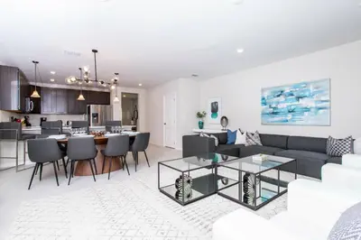 a living room and kitchen with a couch and a table at 4774 Gorgeous Townhome in Kissimmee