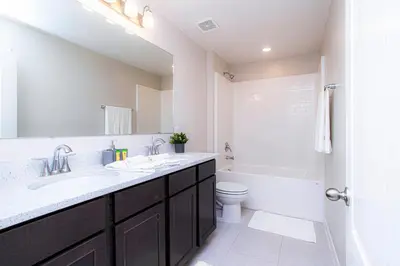 a bathroom with a sink and a toilet and a mirror at 4774 Gorgeous Townhome in Kissimmee