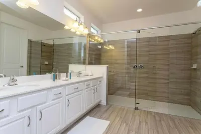 a bathroom with a shower and a sink and a mirror at Luxurious Home Private Pool 2693 in Kissimmee