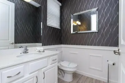 a bathroom with a toilet and a mirror at Luxurious Home Private Pool 2693 in Kissimmee