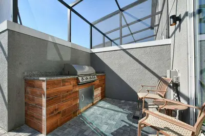 a outdoor kitchen with a stove on a balcony at 4412 Luxurious Townhome Private Pool in Kissimmee