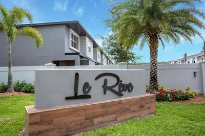 a sign in front of a house with a palm tree at 4412 Luxurious Townhome Private Pool in Kissimmee