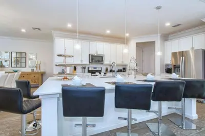a kitchen with a large island with bar stools at 2600YA Luxury Gorgeous Private Pool in Kissimmee