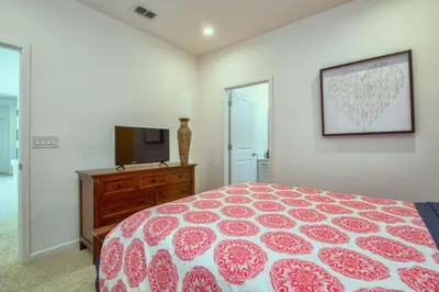 a bedroom with a red and white bed and a tv at 2600YA Luxury Gorgeous Private Pool in Kissimmee