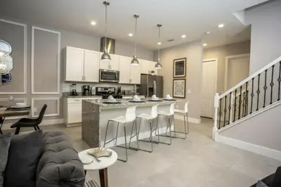 a kitchen and living room with a bar with stools at 2620 Magical Memories 15 min-Disney in Orlando