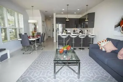a living room with a blue couch and a kitchen at 17419 Awesome Modern w Private Pool in Orlando