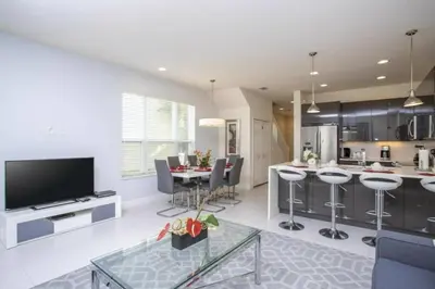 a kitchen and living room with a table and a tv at 17419 Awesome Modern w Private Pool in Orlando