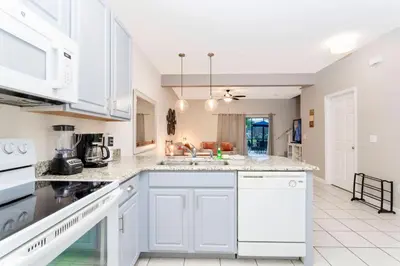 a kitchen with white cabinets and white appliances at Cozy 3 bedroom home with Private Pool 4564 in Kissimmee