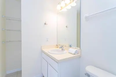 a white bathroom with a sink and a mirror at Cozy 3 bedroom home with Private Pool 4564 in Kissimmee