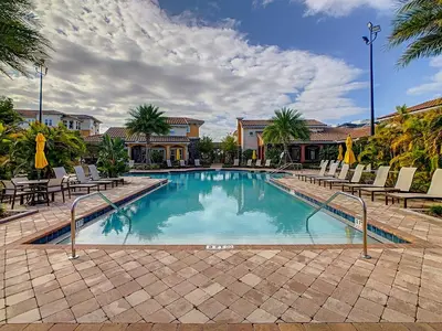 a swimming pool with chairs and a resort at Your Dream Apartment Stay in Kissimmee
