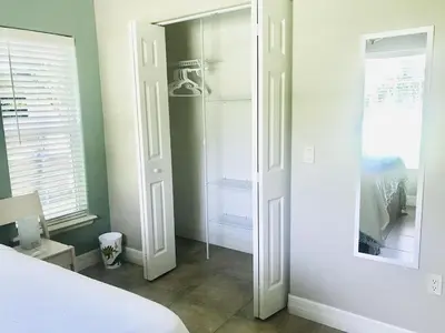 a bedroom with a white bed and a mirror at Hidden City Riverfront Apt Near Lakes Golf & Disney in Kissimmee