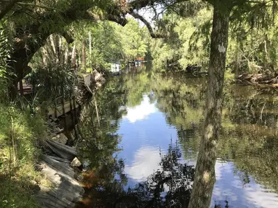 a river with a reflection of the sky in the water at Hidden City Riverfront Apt Near Lakes Golf & Disney in Kissimmee