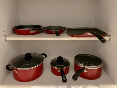 four pots and pans on a shelf in a kitchen at Large Apartment, Close To Disney in Kissimmee