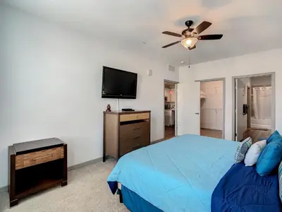 a bedroom with a blue bed and a flat screen tv at Large Apartment, Close To Disney in Kissimmee