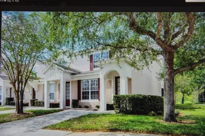 a white house with trees in front of it at Veteran Owned 3bdr/3 bath Townhouse w/WiFi 3mi to Disney - Fall/Winter Specials in Kissimmee