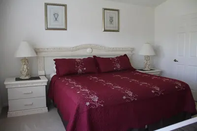 a bedroom with a red bed with two night stands at Veteran Owned 3bdr/3 bath Townhouse w/WiFi 3mi to Disney - Fall/Winter Specials in Kissimmee