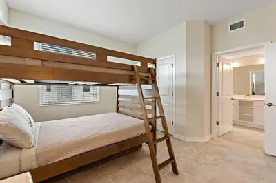 a bedroom with a bunk bed and a bathroom at Triple Header Storey Lake By Shine Villas #700 in Kissimmee