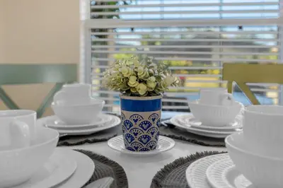 a table with a blue and white vase with a plant in it at Disney Getaway Villa in Kissimmee
