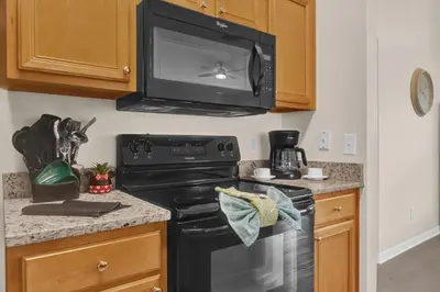 a kitchen with a black stove and a microwave at Disney Getaway Villa in Kissimmee