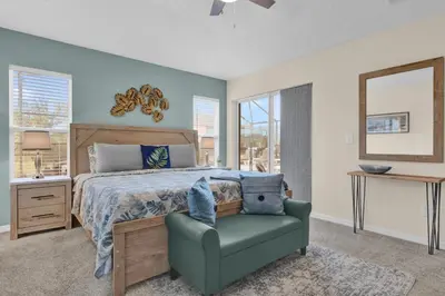 a bedroom with a bed and a chair and a mirror at Disney Getaway Villa in Kissimmee