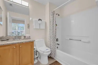 a white bathroom with a toilet and a shower at Disney Getaway Villa in Kissimmee