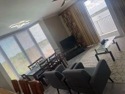 a living room with chairs and a table and a television at Lake view condo close to Disney in Orlando