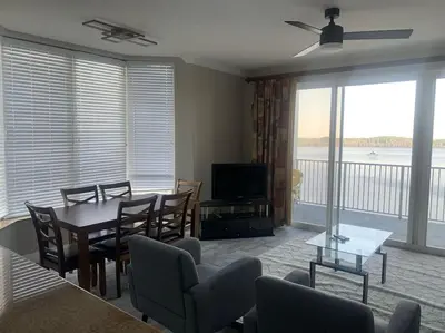 a living room with a table and chairs and a television at Lake view condo close to Disney in Orlando