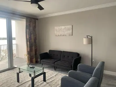 a living room with a couch and a glass table at Lake view condo close to Disney in Orlando