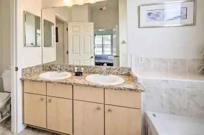 a bathroom with two sinks and a large mirror at Dog-Friendly Kissimmee Home with Lanai and Pool! in Kissimmee